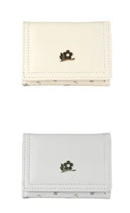 Gros plan de portefeuilles en cuir beige et gris avec garniture florale et logos