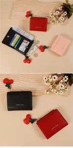 Gros plan d'un portefeuille à pendentif cerise avec fentes pour cartes et cuir