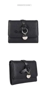 Macro shot of black litchi texture leather wallet with silver round pendant detail
