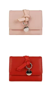 Détail des portefeuilles en cuir grainé rose et rouge avec des anneaux en métal argenté