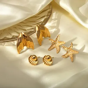 Golden stainless steel mermaid tail, starfish and shell earring set on silk background