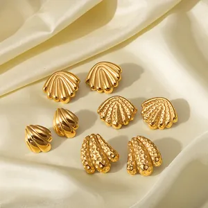Set of four 18k gold plated shell-shaped stainless steel earrings on silk background