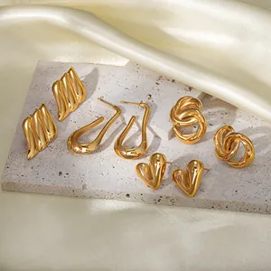 Set of four pairs of 18k gold plated stainless steel earrings on a silk background