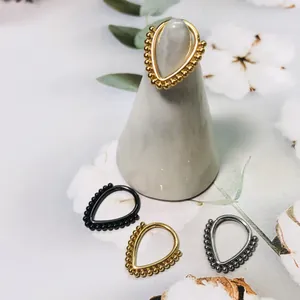 Detailed view of teardrop 316L stainless steel rings with beaded edges in gold and silver