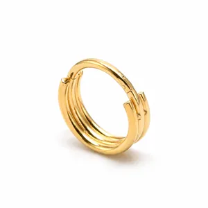 Macro shot of three-layered golden stainless steel nose ring with secure closure mechanism