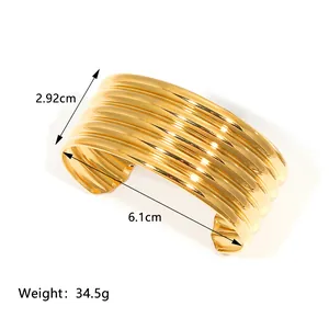 Macro view of 18K gold plated rippled wide cuff bangle with size measurements