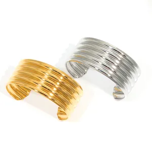 Macro detail of multi-layer wavy textured cuff bangle in gold and silver finish