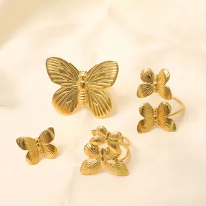 Exaggerated 18K gold plated stainless steel butterfly rings on luxury silk background