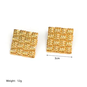 Macro shot of 18K gold plated earrings with a 3cm square woven texture and metallic finish