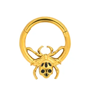 Detail of golden spider septum clicker with black gemstones on a white background