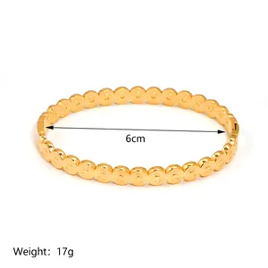 Detailed view of 18K gold plated bangle with overlap ring texture and 6cm diameter