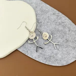 Dettaglio ravvicinato di orecchini doodle in argento su uno sfondo di piatto in ceramica