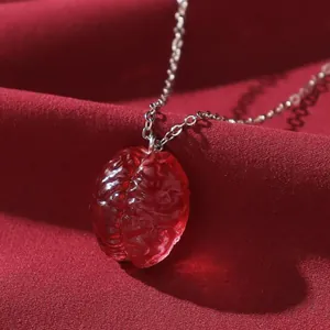 Collana surrealista con pendente a cervello rosso traslucido e catena in metallo