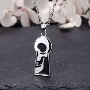 Collier pendentif crâne gothique en argent et émail noir dans un cadre de trou de serrure