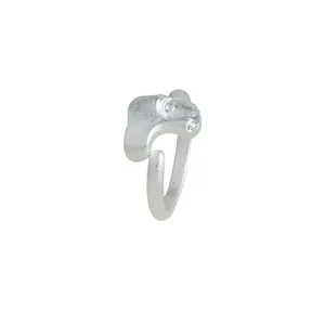 Bague ouverte argentée en forme de masque avec texture mate sur fond blanc pur