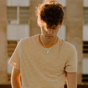 Détail d'un collier vintage en acier inoxydable avec crâne et serpent sur un homme