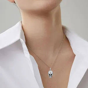 Pendentif tête de mort gothique avec croix porté par un mannequin sur chemise blanche