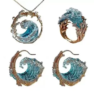Kunstvolles Wellen Schmuckset mit goldener Halskette, Wellenring und C-Ohrringen