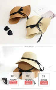 Detail of woven straw hats in beige and khaki with black bow ribbons for sun protection