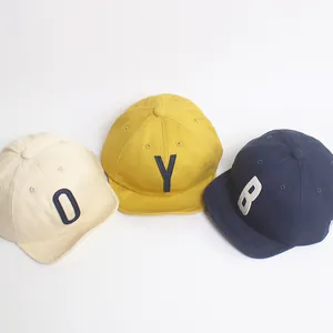Détail de casquettes en coton pour enfants avec broderie O, Y, B et visière souple
