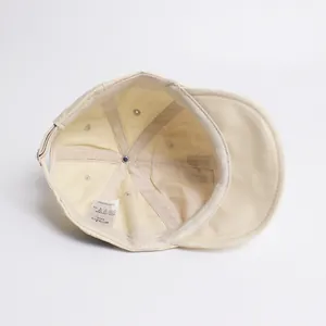 Vue intérieure d'une casquette en coton beige pour enfants avec bord souple et étiquette