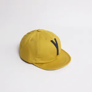 Détail d'une casquette de baseball jaune pour enfant avec patch brodé de la lettre Y