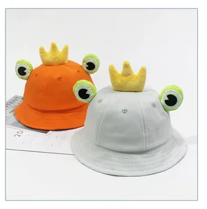 Détail de chapeaux bobs pour enfants en coton avec couronne en peluche et yeux de grenouille