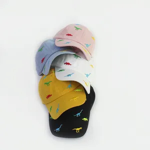 Detailed stack of kids cotton baseball caps featuring colorful dinosaur embroidery