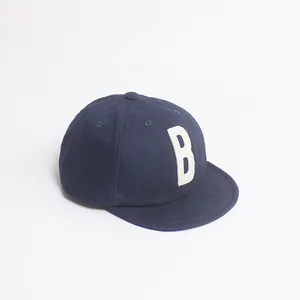 Vue détaillée de la casquette bleue en coton avec écusson lettre B et visière souple