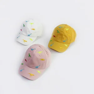 Detailed close-up showing colorful cartoon dinosaur embroidery on cotton baseball caps