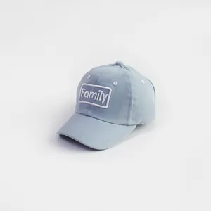 Detail of blue cotton kids baseball cap with white Family embroidery on white background