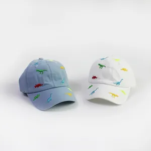 Detail of light blue and white kids baseball caps with colorful dinosaur embroidery