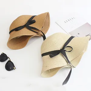 Women's summer straw hat with black ribbon bow and wide brim for sun protection