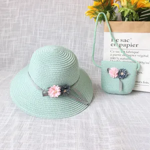 Detail von hellgrünem Strohhut und passender Tasche mit floralen Bandakzenten