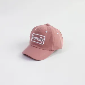 Close-up of Family letter embroidery patch on dusty pink cotton kids baseball cap