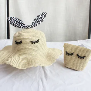 Dettaglio set cappello e borsa in paglia con ciglia decorative e fiocco a zig-zag
