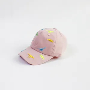 Close-up of colorful dinosaur embroidery on premium pink cotton kids' baseball cap