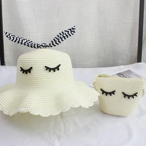 Dettaglio del set cappello e borsa in paglia con ciglia decorative e orecchie di coniglio