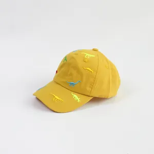 Detail of breathable yellow cotton kids baseball cap with colorful dinosaur embroidery