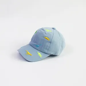 Close-up of light blue cotton baseball cap featuring colorful dinosaur embroidery details