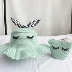 Dettaglio set cappello e borsa di paglia verde menta con ricamo ciglia e fiocco