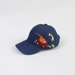 Close-up of bear driving car embroidery on dark blue denim kids baseball cap