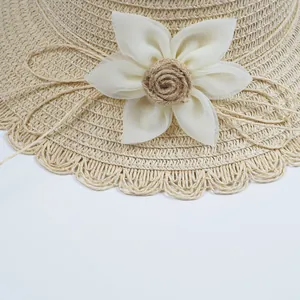 Straw sun hat for kids featuring scalloped edges and a decorative white fabric flower
