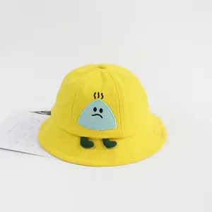 Detalle de gorro de sol para bebé con parche de dibujo animado sobre algodón amarillo
