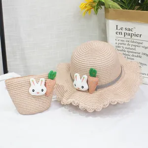 Dettaglio di cappello di paglia per bambini e borsa con decoro a coniglio e carota