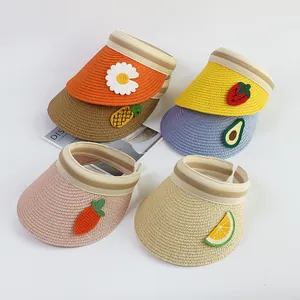 Detailed close-up of straw visors with cute knit fruit patches in various bright colors