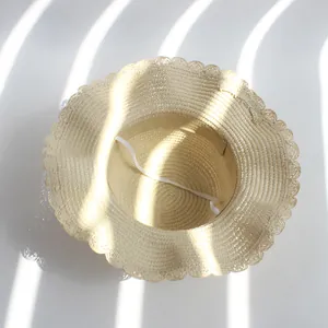 Détail d'un chapeau de paille pour filles avec bord ondulé et mentonnière élastique