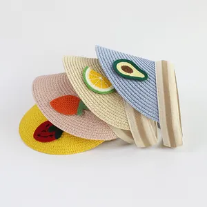 Detail of straw sun visors with fruit patches and elastic bands for children