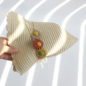 Chapeau de paille beige pour enfants avec fleurs décoratives et bordure en dentelle