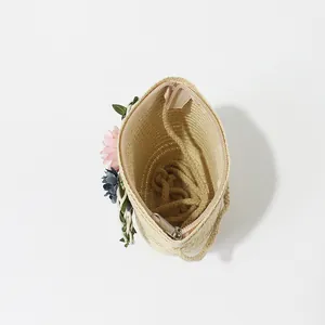 Detail of straw woven bag with zipper closure and floral accents for children